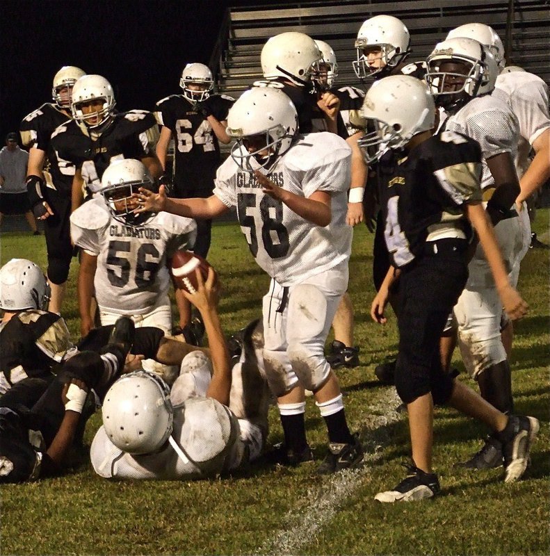 Image: Taking the rock — Cody Medrano comes away with the ball as Kyle Fortenberry helps him celebrate his fumble recovery.