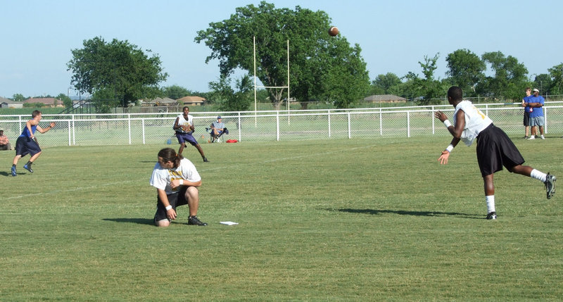 Image: Jasenio — Jasenio sails one long to John “Booney” Isaac for a first down while center Zach Hernandez looks on.
