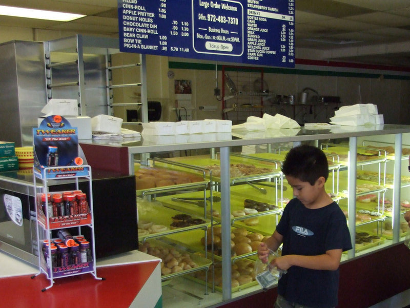 Image: How Many Donuts Can I Buy — This young man is making sure he has enough money for his donuts.