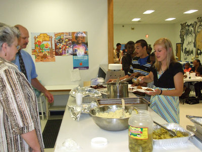 Image: Let’s eat! — Principal Marilee Byrne and Superintendent Don Clingenpeel help serve brisket and sausage to get the banquet cooking.