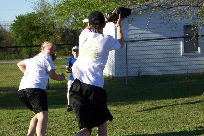 Image: In a pickle — Jaclynn Lewis and pals Ty Windham and Collin Westbrook play a run-down game called “Pickle” behind the concession stand during the game.