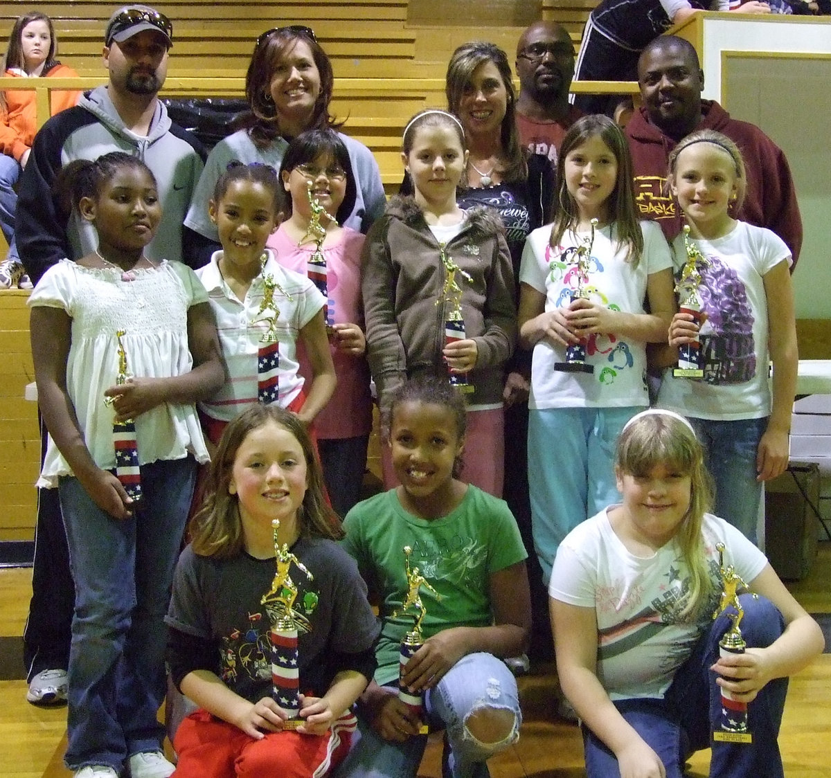 Image: Haight’s Hoopsters — Head Coach Tina Haight and her Assistant Coaches Casey and Shawn Holden pose with their team. Haight’s Hoopsters played in one of the most exciting games of the 2009 season.