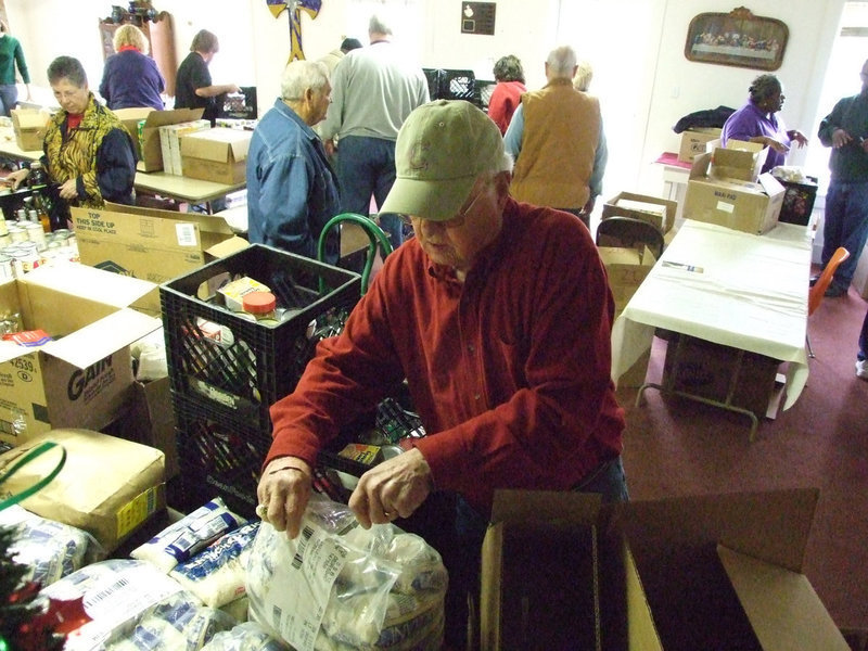 Image: Rice for everyone — Kenneth Crowell opens bags of rice for the Christmas basket delivery for Italy residents. The Italy Ministerial Alliance delivers food and turkeys every year to people in need.