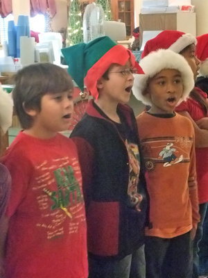 Image: Giving Their All — These three second graders are busy singing.