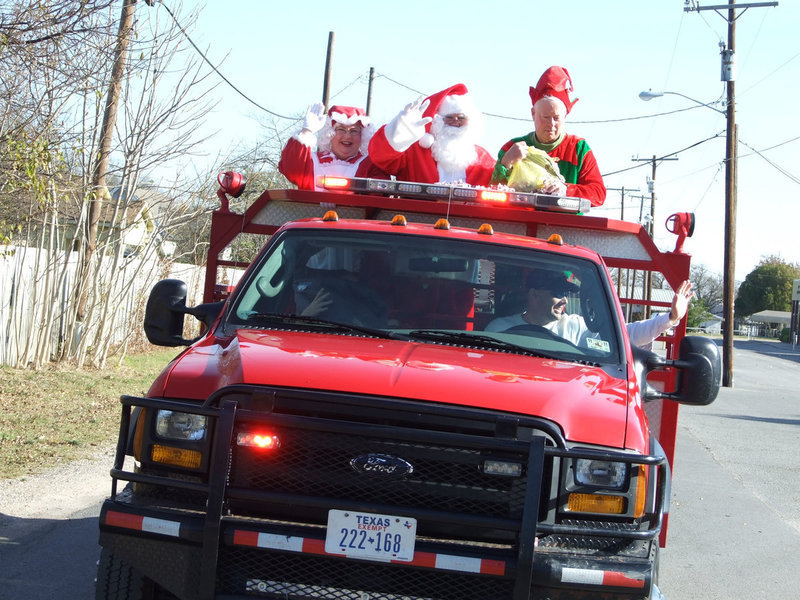 Image: Santa has come to town — Mr. and Mrs. Claus were guests in the Italy Festival on Saturday. Santa had to rush back to the North Pole to be ready for the 25th. Elf Crownover was happy to give out candy.