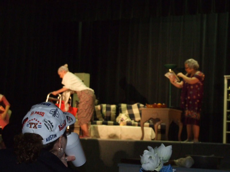 Image: Madge Has Had Enough — Madge has heard enough of Louise’s ranting and raving and is leaving the room as fast as her walker will take her.