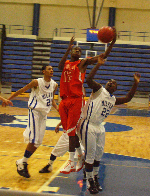 Image: SENIOR #12 — Dernard jumps miles off the ground to grab the rebound against Milford.