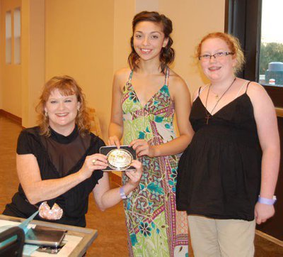 Image: Yearling halter buckle — Julie Hinz, seated, is presented with the champion buckle for Yearling Halter, by buckle sponsor PTL Construction of Palmer representatives Brooke and Chloe Lewis.