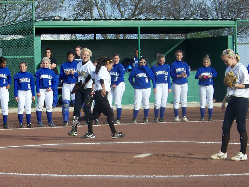 Image: Glove slap — Megan and Marisela slap gloves during pre-game team introductions.