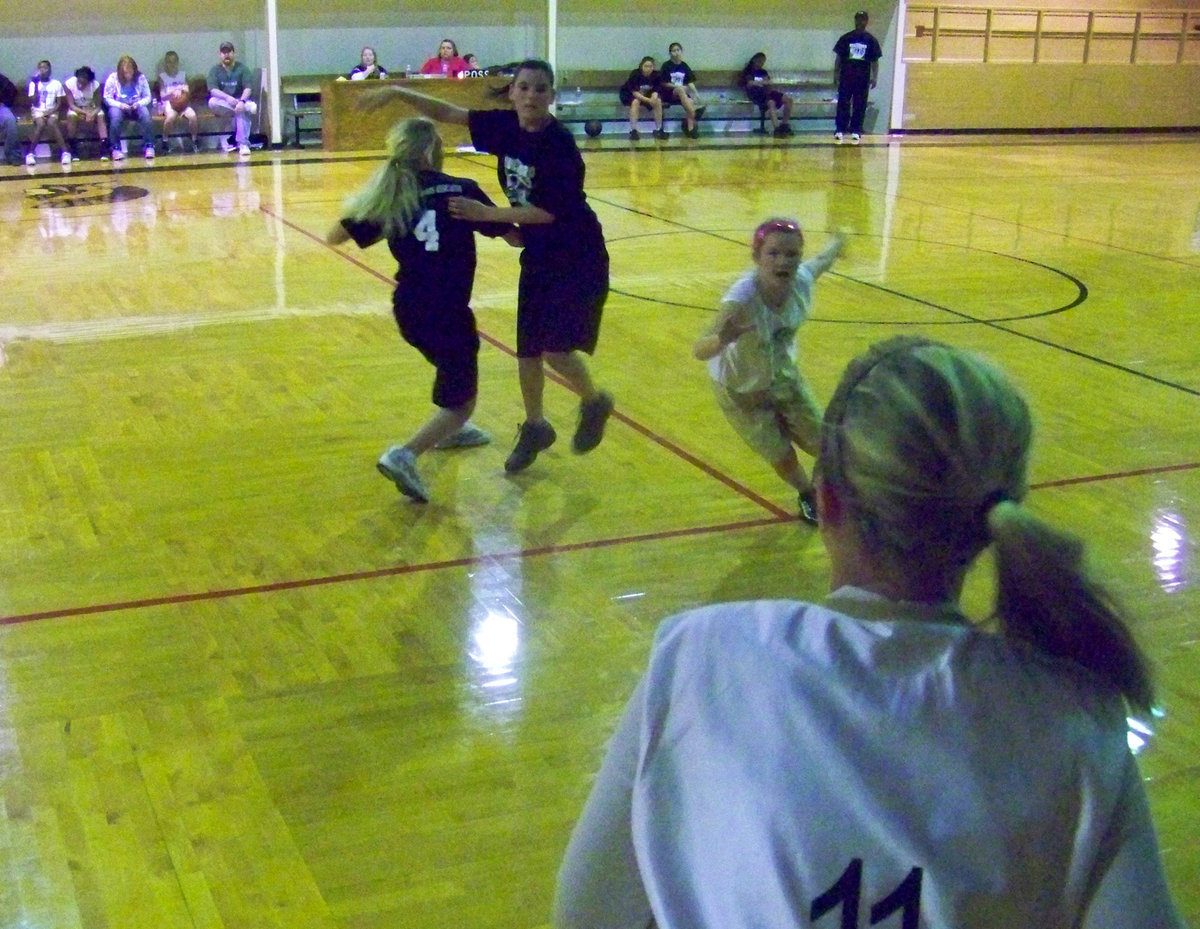 Image: Dizzy — Italy 23’s Madison Washington #11 tries to pass to swirling Tara Wallis #9.