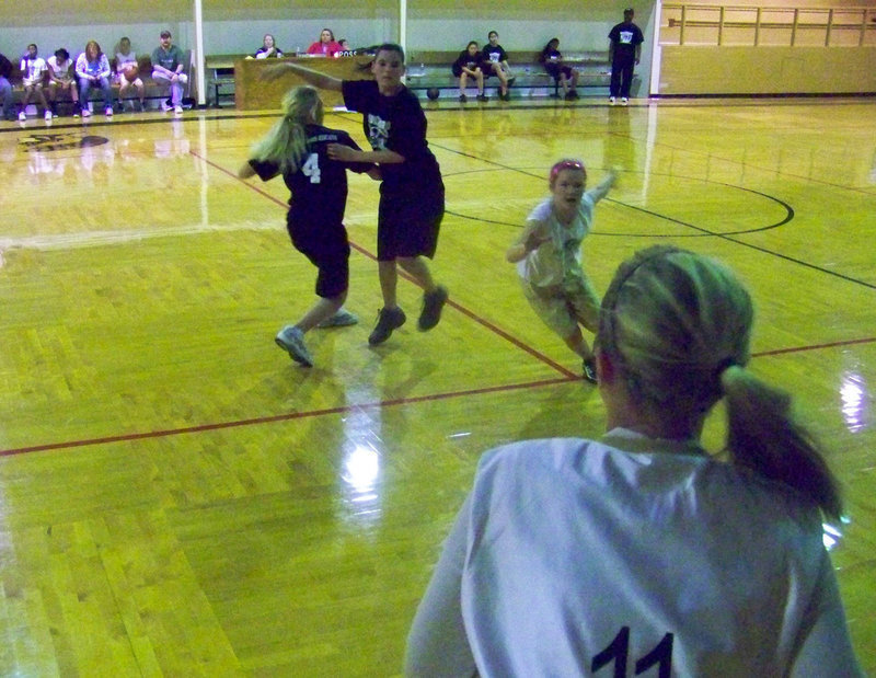 Image: Dizzy — Italy 23’s Madison Washington #11 tries to pass to swirling Tara Wallis #9.