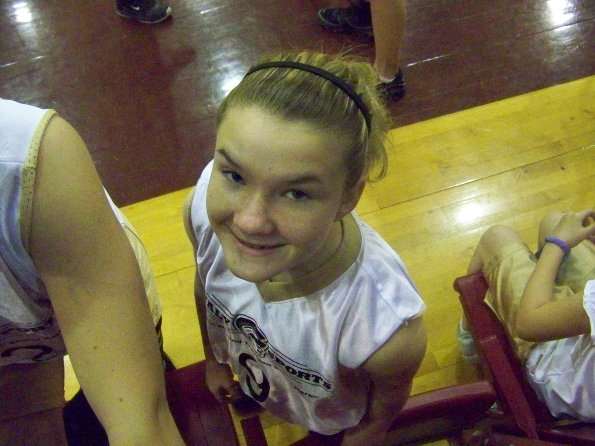 Image: Tara cheeses — No, no! Do not let that innocent smile fool you. Point guard Tara Wallis is an animal on the court. If there is a loose ball…Tara dives for it. If there is a missing ball…Tara stole it. And if you get in her way…Tara will shoot over you.