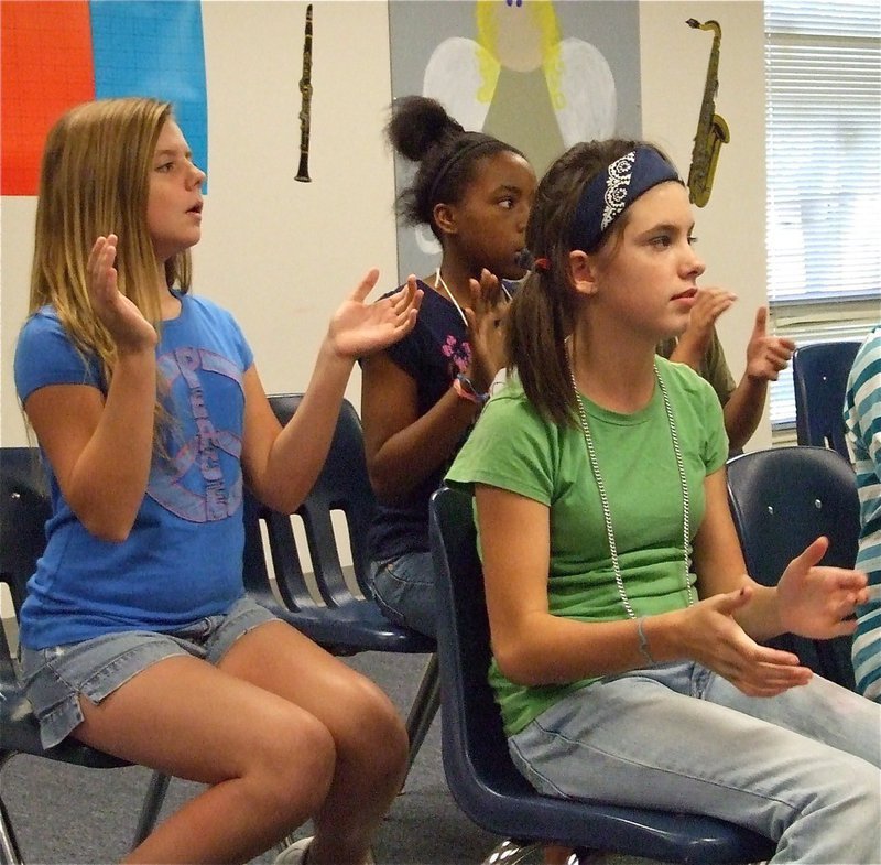 Image: Can you lend a hand? — With no instruments handy and hoping for instrument or financial donations from the community, Brooke, Quintera and Aaron clap along to the beat of the metronome scale.
