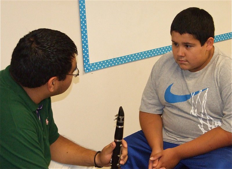Image: Which do you prefer? — Jesus Perez helps Adrian decide which band instrument would be best suited for him….if the band actually had available instruments.