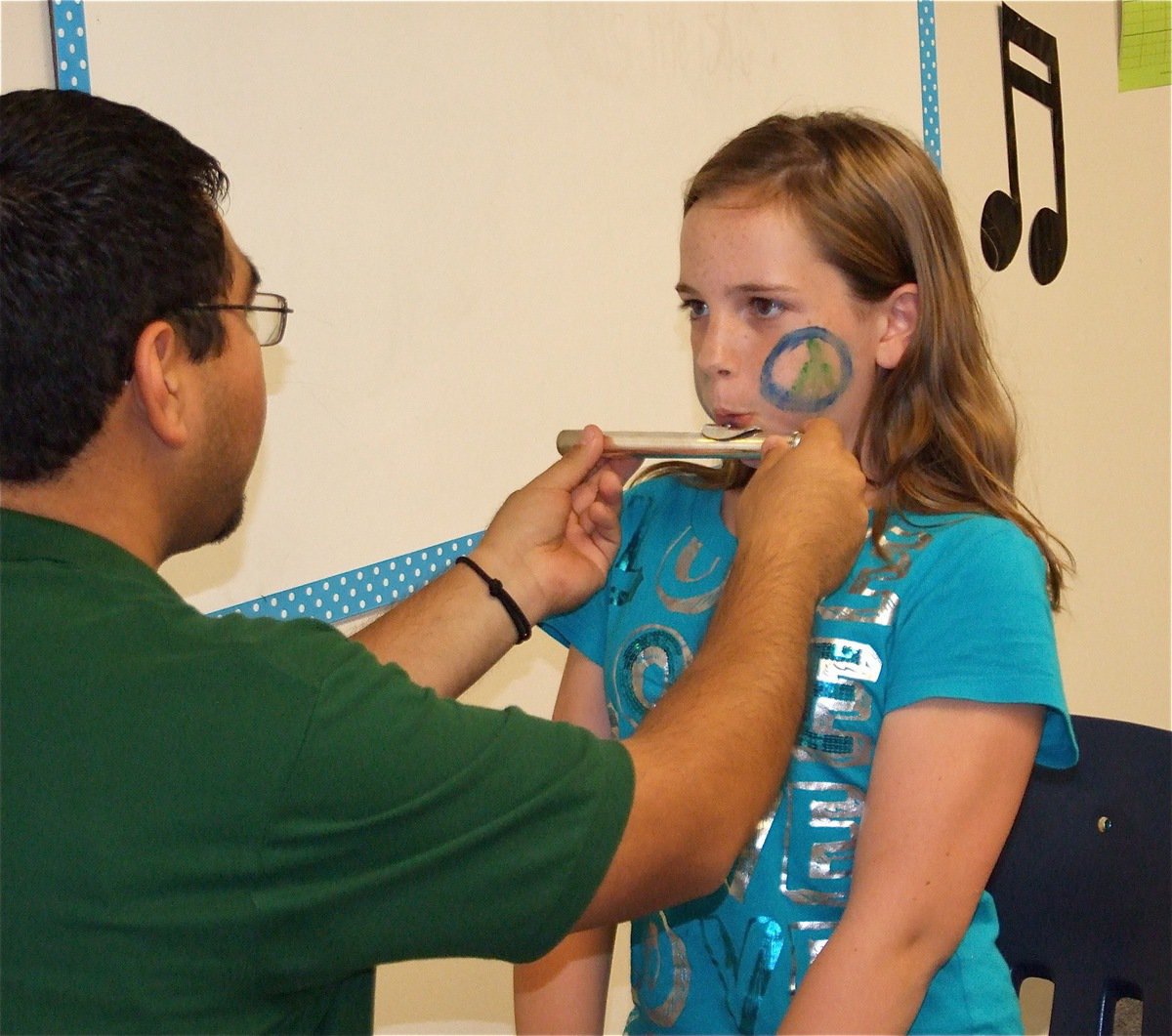 Image: Flute, maybe? — Sarah goes for it during the instrument test in an effort to choose which band instrument would be best suit her.