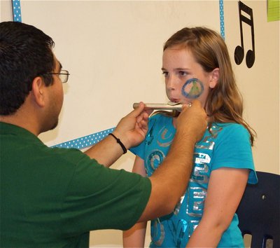 Image: Flute, maybe? — Sarah goes for it during the instrument test in an effort to choose which band instrument would be best suit her.