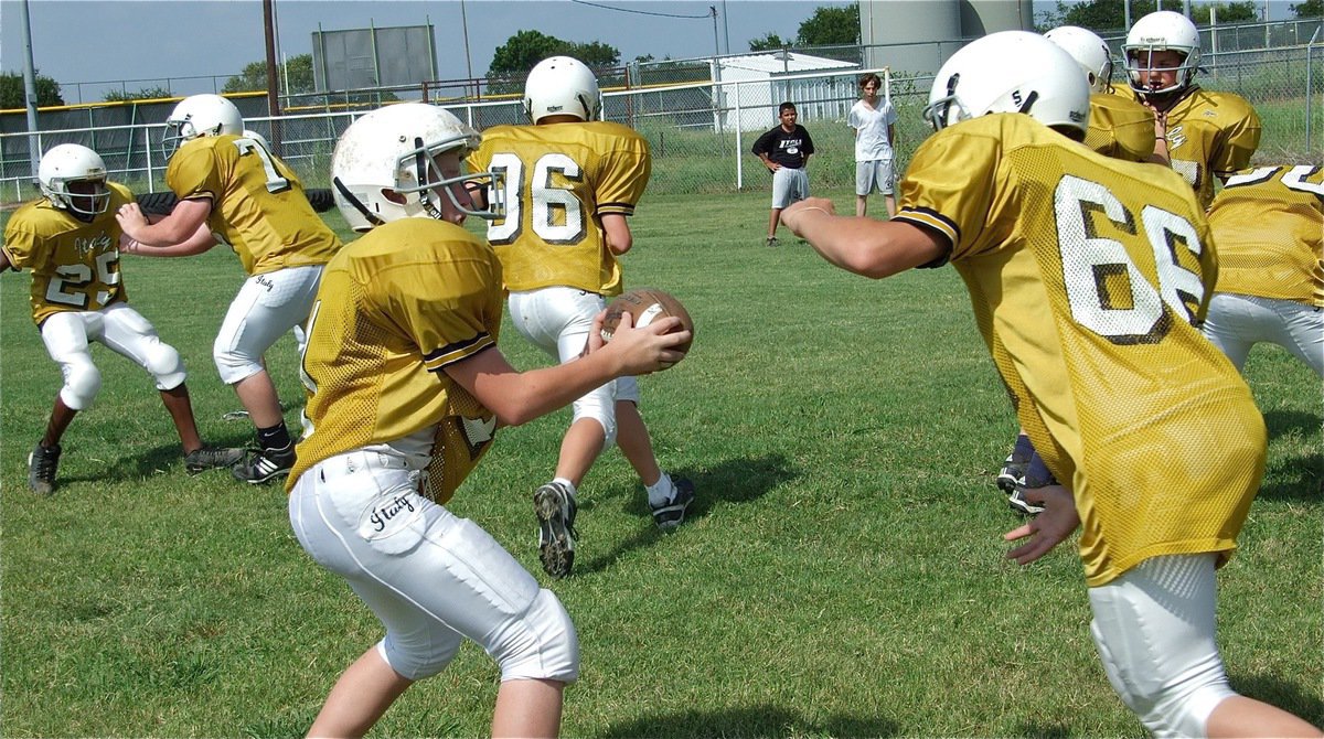Image: Heavy rains spare Palmer from Italy’s talented Junior High team — John Escamilla(1) hands off to Coby Bland(66) during Thursday’s practice. The Italy Junior High made the most of the day despite having their scrimmage against Palmer cancelled after heavy rains earlier in the week soaked Willis Field.