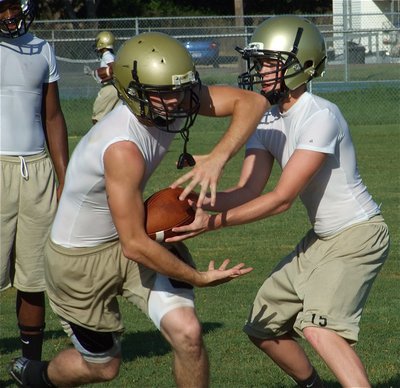 Image: Justin to Kyle — Justin Buchanan hands off to Kyle Wilkins.