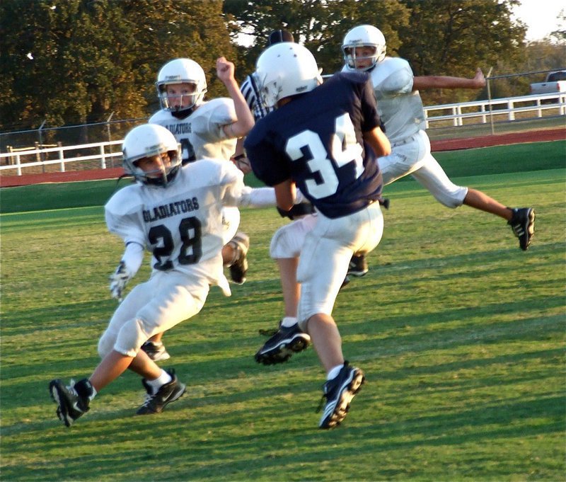 Image: Pass! — Levi McBride(28), Cody Boyd(22) and Colton Petrey(6) jump out into pass coverage.
