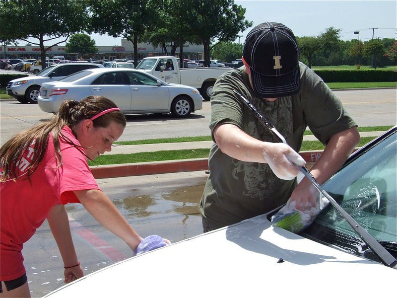 Image: Teaming up — Reagan Cockerham scrubs the fender while Brett Kirton gets under the wiper.