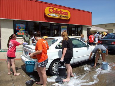 Image: Nice rhythm — IHS Band members march around the cars cleaning all the way.