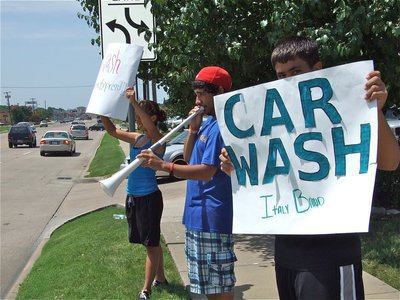 Image: Eat more chicken! — Jennifer Hernandez and Reid Jacinto hold the signs and Michael Martinez toots his own horn, all in an effort to attract customers to the Chicken Express Restaurant.