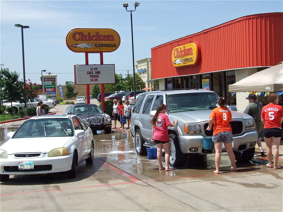 Image: Plenty of autos — Drivers take advantage of the IHS Band fund-raising car wash.