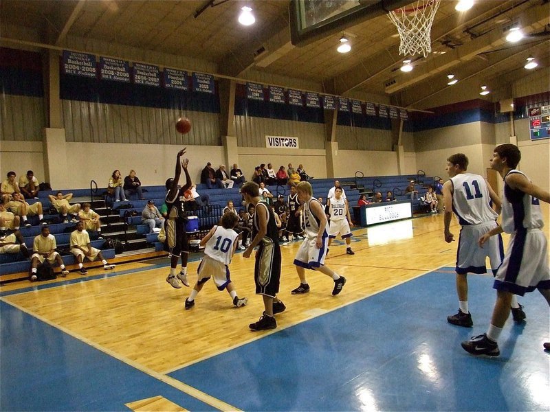 Image: A  J.V. Gladiator hits a jumper from the wing over a Bulldog defender.