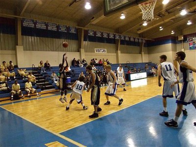 Image: A  J.V. Gladiator hits a jumper from the wing over a Bulldog defender.