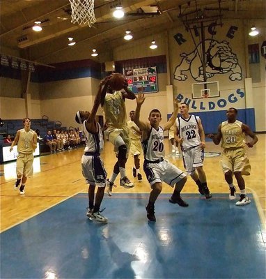 Image: Excuse me! — Jasenio Anderson(11) splits two Bulldog defenders on his way to the hoop and an 18-point night.