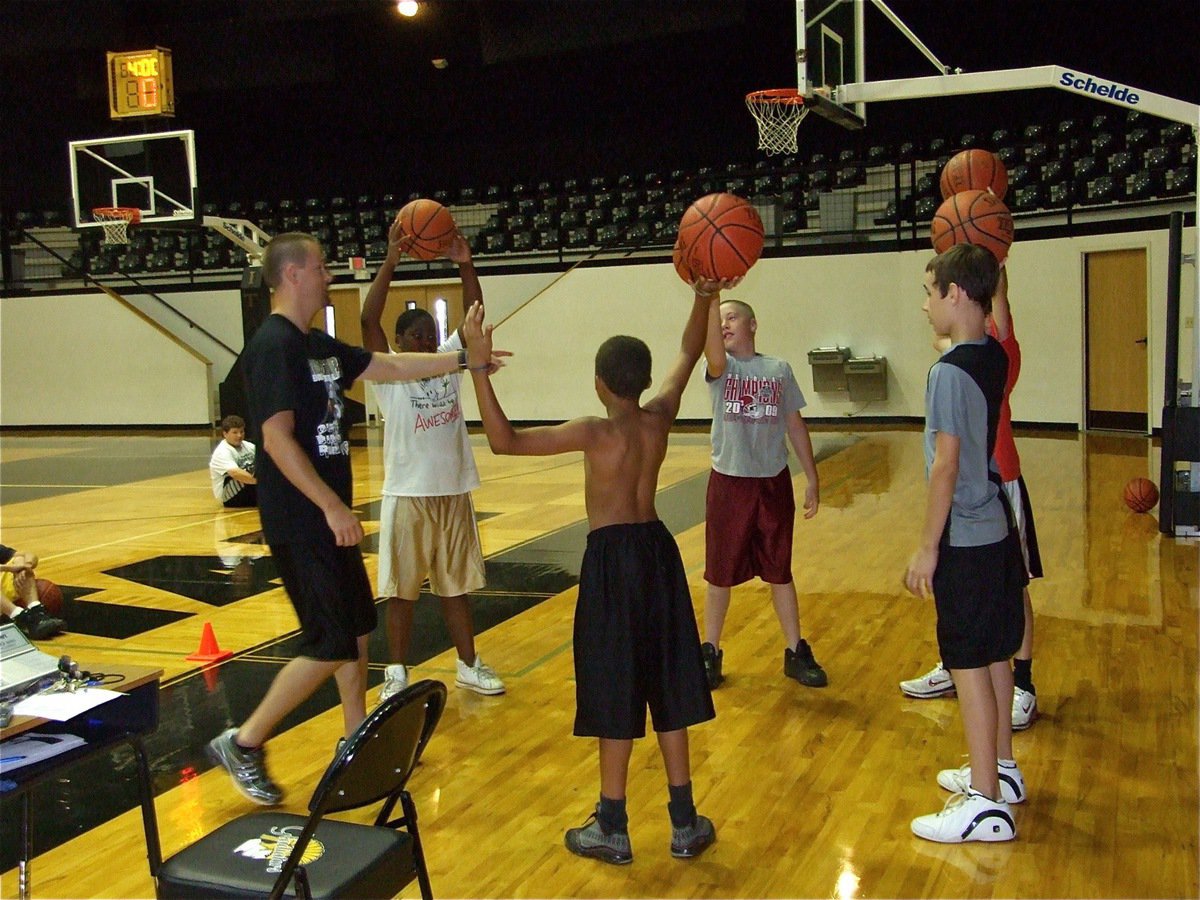 Image: Coach selects winner — Coach Cal points to a winner after a ball handling challenge.