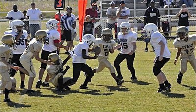 Image: Ball flips out — Jasean Brooks(11) causes the Bulldog runner to loose the handle on the ball.