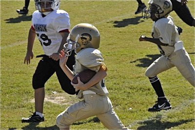 Image: Garrett gashes defense — Garrett Cash(28) breaks tackles down Italy’s sideline for a big gain against Dawson. Cash also scored on an extra point conversion run for the IYAA Minors team.