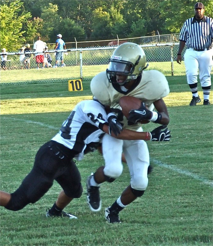 Image: A Bulldog locks on — Italy’s Eric Carson(28) tries to escape the grasp of a Bulldog defender.