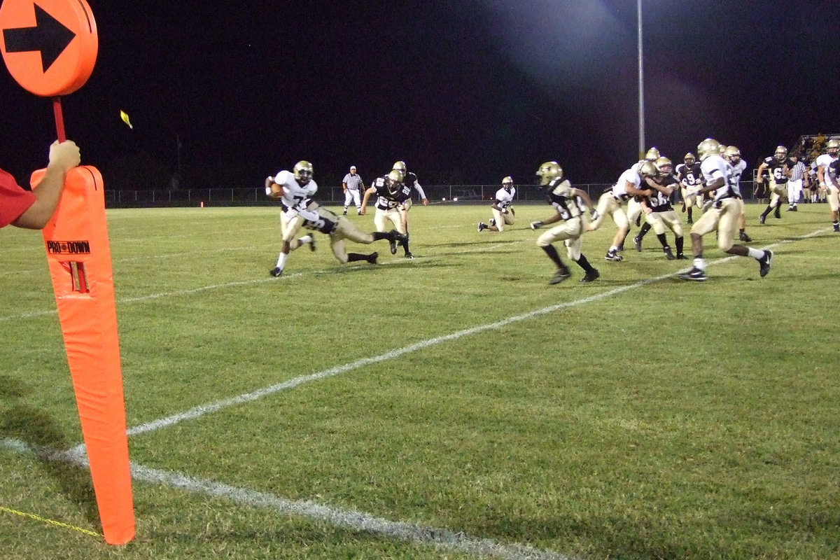 Image: Anderson runs — #7 Jasenio Anderson dragging a Jaguar with him, runs around the right side.