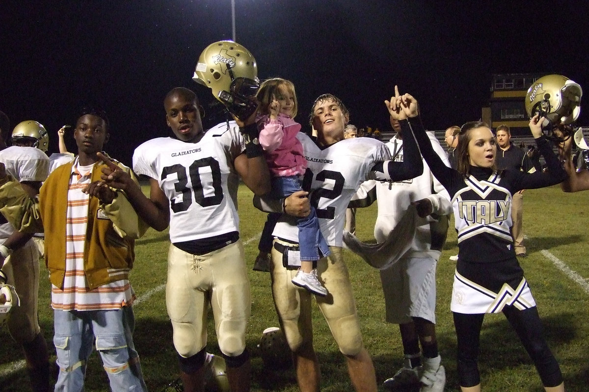 Image: Family support — Sisters and brothers help line the field for victory.