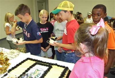 Image: In line for treats — IYAA players and cheerleaders lineup for cake, cookies and punch.