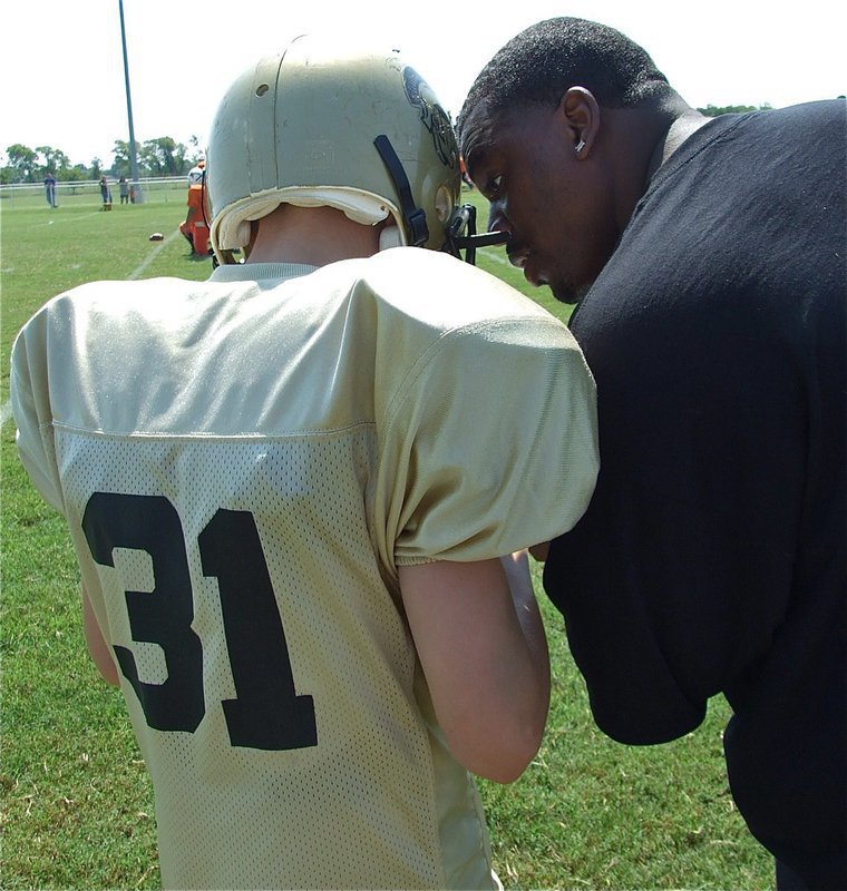 Image: Riddle gets the play — Clay Riddle gets the play call from the Majors’ assistant coach Edwin Wallace. Clay’s homecoming day performance marks the first time in twenty years a Riddle has played football on Willis Field.
