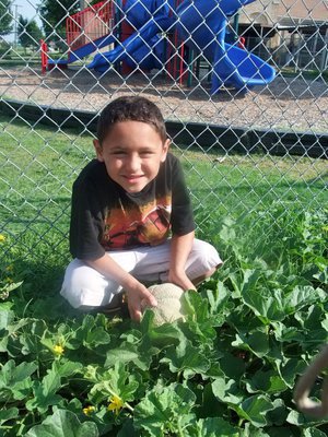 Image: I Found Another One — This young man is very proud of his cantaloupe.