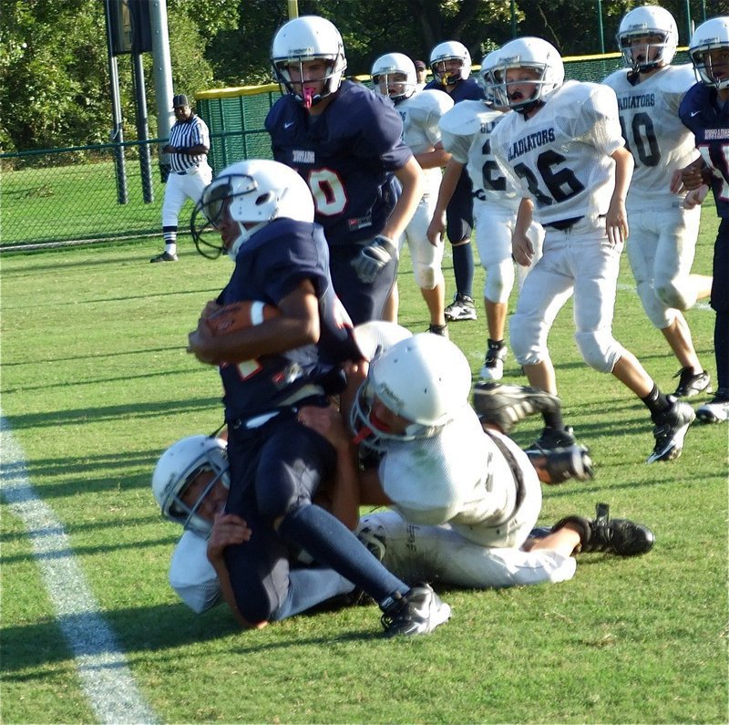 Image: Game of inches — Italy’s Colton Petrey and Chace McGinnis try to drag down this Mustang runner before he can cross the goal line.