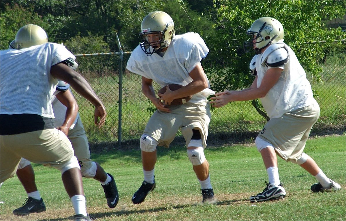 Image: It’s all yours — Justin Buchanan hands off to Kyle Jackson during Wednesday’s practice.