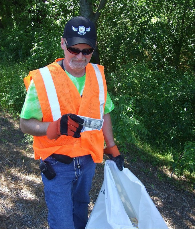 Image: It’s worth it — In a matter of minutes, the Hwy 77 cleanup effort paid dividends as Mike Ritchy finds a dollar to donate to St. Judes Hospital in Memphis.