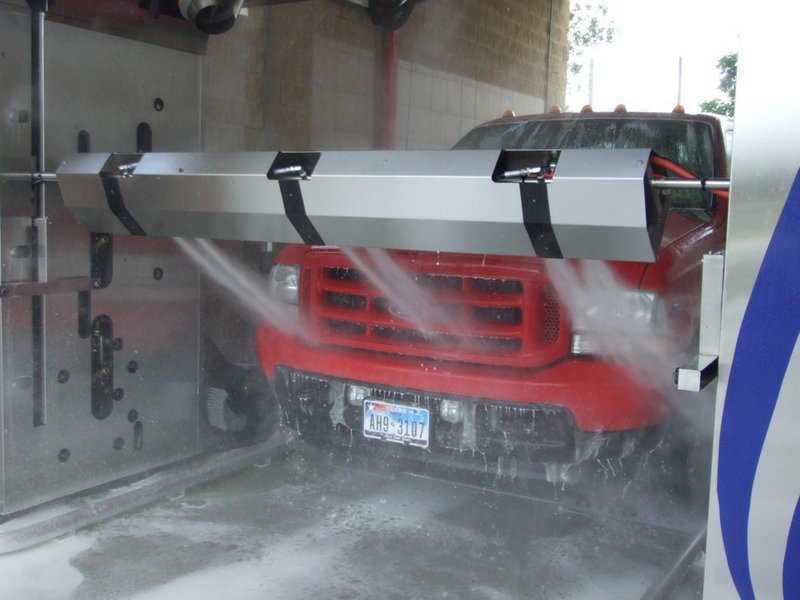 Image: Clean grill — Lowering the boom. Controlled by sensors, the boom follows the contour of the vehicle so cars and trucks get equally clean.