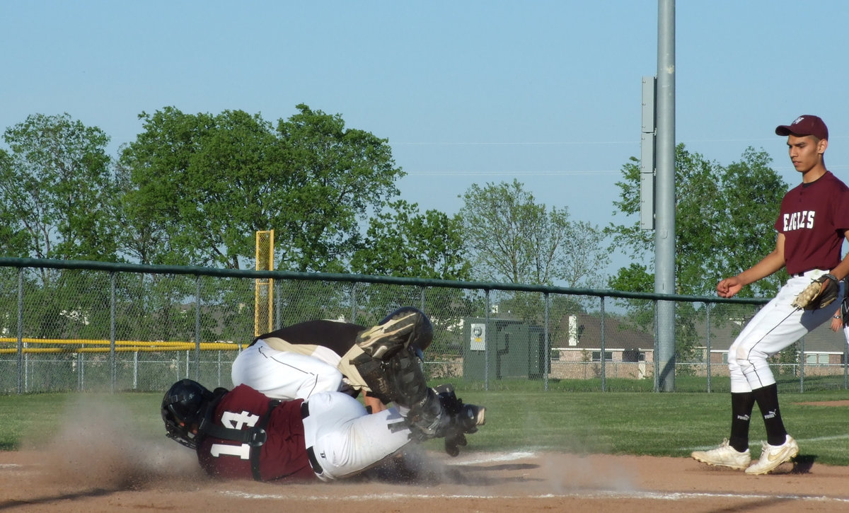 Image: A little bit of dust flying — Brandon Souder and a Waxahachie Eagle toss a little sand at home plate on Friday. Souder was running to home when the catcher tried to tag. Italy gained the point.
