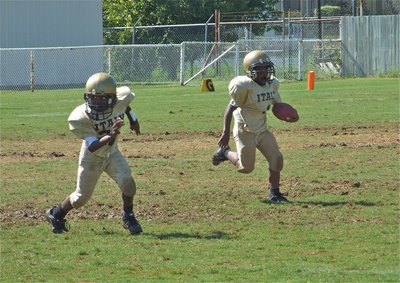 Image: This way! — Kendrick Norwood(1) sweeps left to make it difficult for the Lions to stalk him as Taron Smith(21) leads the way.