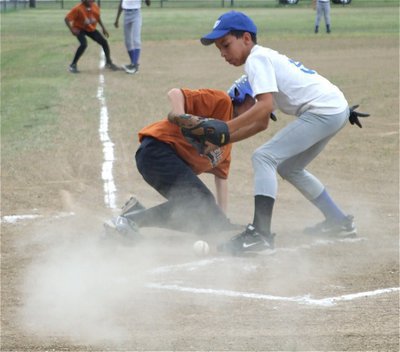 Image: Dusty, but safe! — With rain clouds on the horizon, Ty Windham creates a dust storm by sliding home to score a run against Whitney.