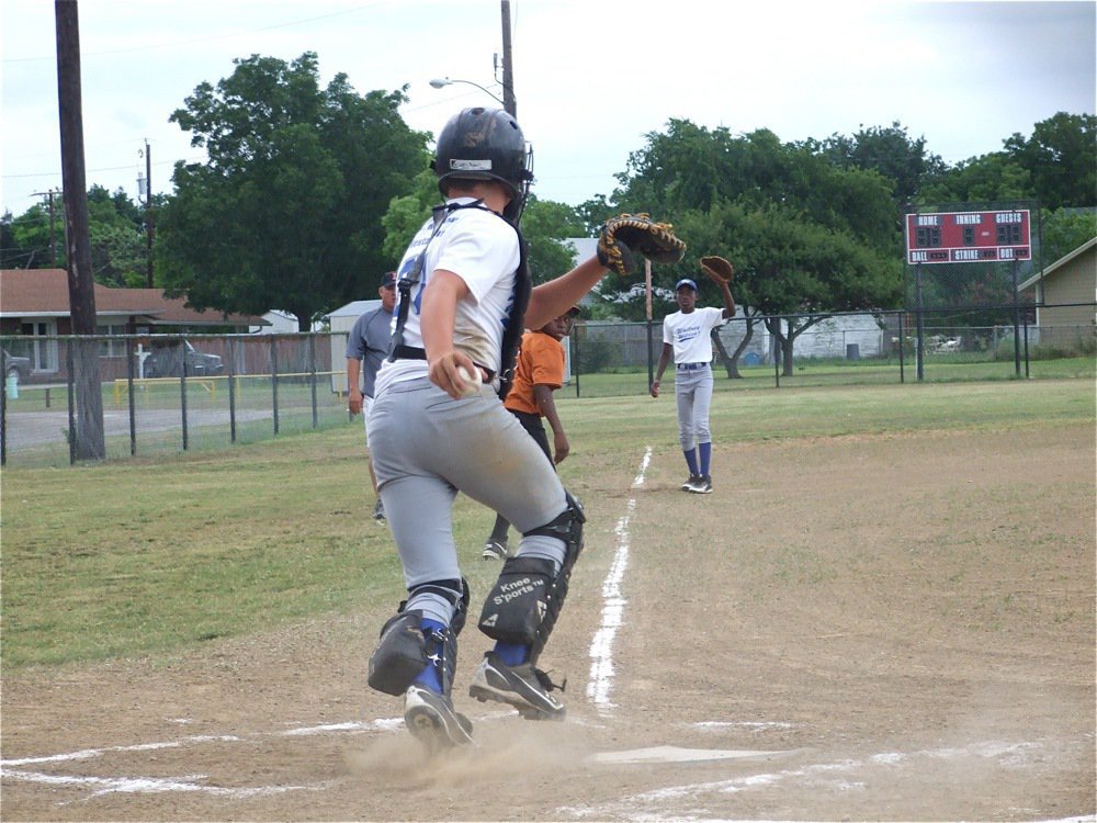 Image: Lil’ bit lucky — Kevin “Lil’ K” Johnson draws attention to himself and gets in a run down between third base and home. Johnson eventually crossed the plate for a score standing up.