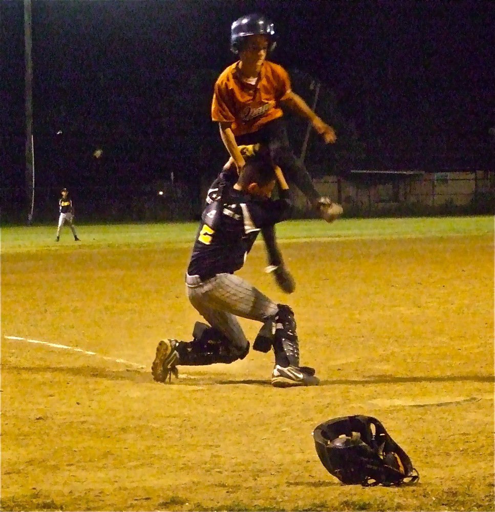 Image: Dramatic play — Levi McBride tries leaping over Itasca’s catcher in a gutsy attemt to give Italy the lead late in the game. Itasca’s catcher displayed guts as well and held on to the ball for an out.