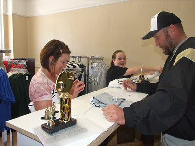 Image: Ordering shirts — Dustie and her daughter Raegan place an order with Erick Thompson of Game On Athletics.
