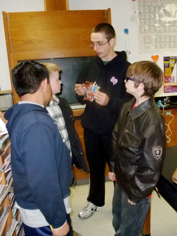 Image: It Looks Like This — Aaron Polacios, Blake Faber and Nick Brazal take instruction from senior Sheldon Kennison about how to build the Jitterbug.